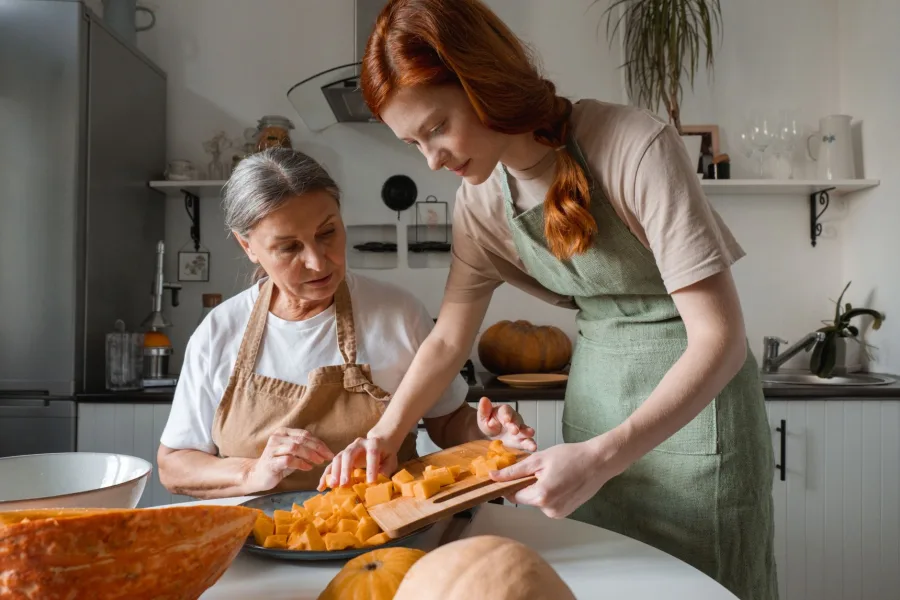 A caregiver preparing a meal with a senior